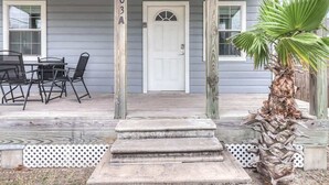 A house with a porch, a white door, and a number '203A' on the post.