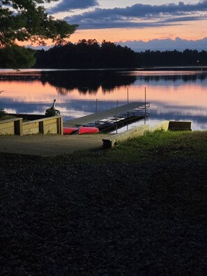 A lakeside dock with a rowboat, a small boat, and a canoe. - Beavers Resort - Cabin 4 (Mercer)