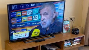 A television on a wooden stand with a shelf below displaying books and a mug. - 1 bed & 1 bath apartment large balcony - 10 min walk from new street station (Birmingham)