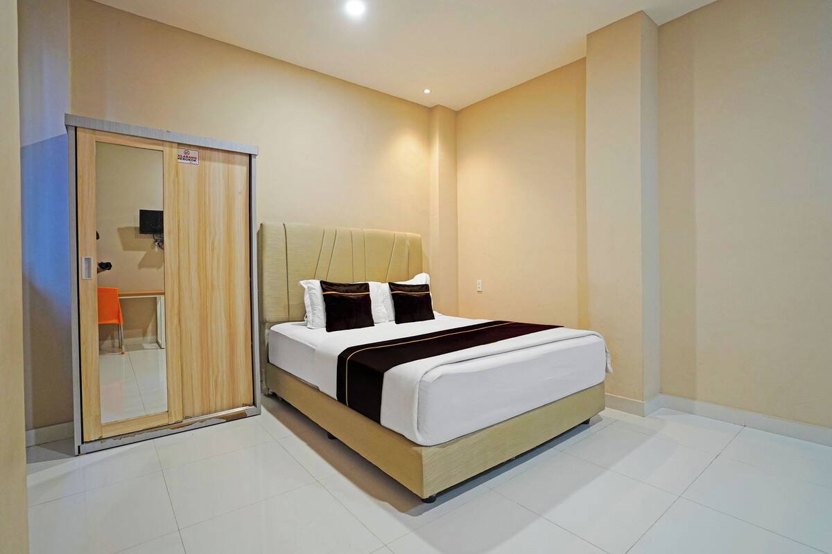 Ein Hotelzimmer mit Bett, Kleiderschrank und einer kleinen Sitzecke.