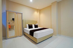 A hotel room with a bed, a wardrobe, and a small seating area. - Hotel O near Masjid Raya Baiturrahman (Banda Aceh)