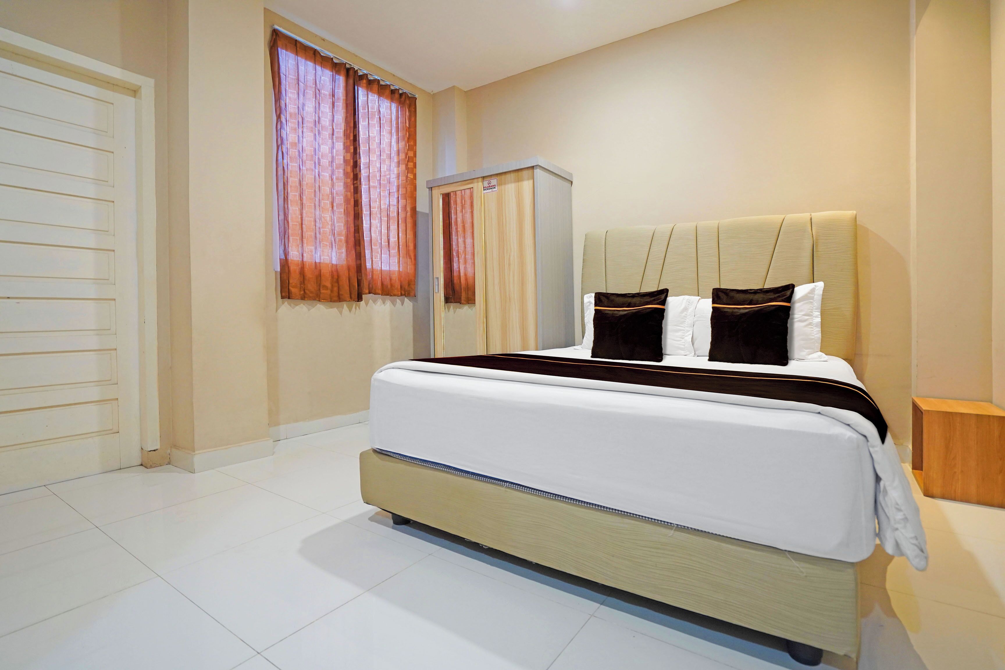 A bedroom with a bed, a wardrobe, and a nightstand.