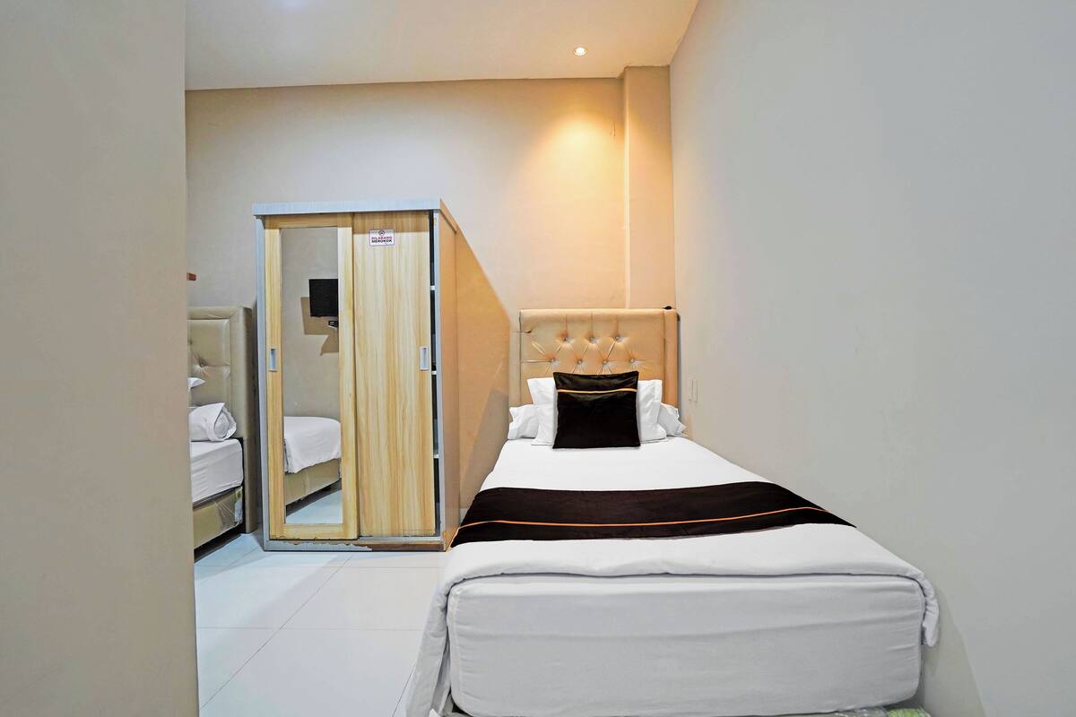 Ein Hotelzimmer mit einem Bett, einem Kleiderschrank und einem Spiegel.