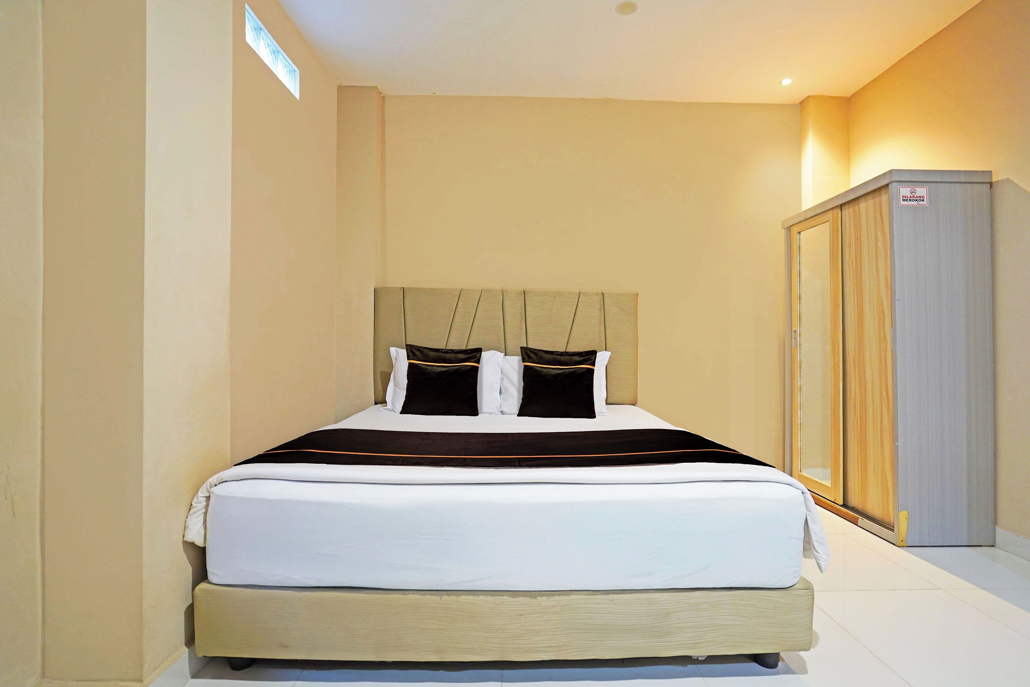Une chambre d’hôtel avec un lit, une armoire et une fenêtre.