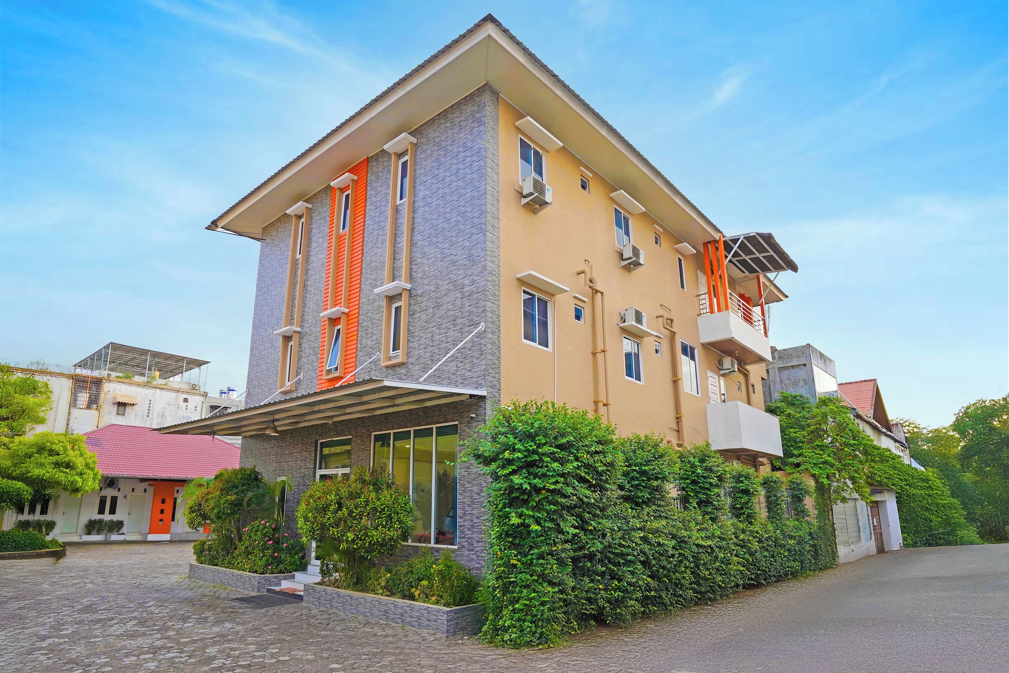 Un edificio a più piani con tetto piatto, ampie finestre e un ingresso coperto.