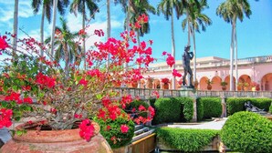 A courtyard with a statue, palm trees, and a fountain. - The Lovely Gem 6 miles to Siesta Key Paradise (Sarasota)