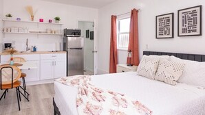 A modern hotel room with a bed, a dining area with a table and chairs, a kitchen area, and a bathroom. - The Lovely Gem 6 miles to Siesta Key Paradise (Sarasota)