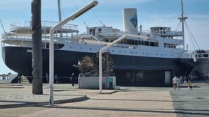 A large ship docked at a port with a clear sky.