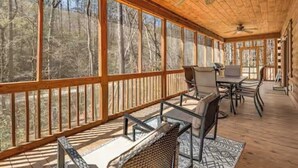 A covered outdoor area with a table and chairs, large windows, and a ceiling fan. - NEW CABIN!-Pet Friendly-Babbling Brook-Private Lake-Grill (Lake Lure)