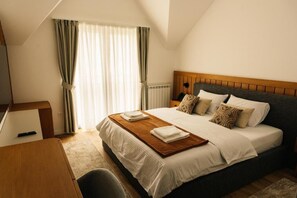 A hotel room with a bed, a desk, and a window with curtains. - Hotel Nordik (Moticki Gaj)