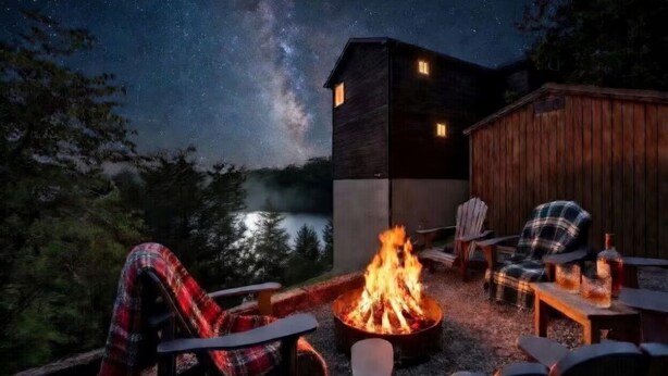 A cozy outdoor seating area with a fire pit, chairs, and a view of the night sky. - New Listing! Cabin On The Lake, Hot Tub, Game Rm! (Sevierville)