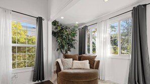 A room with a large window, a brown sofa, and a plant. - Beverly Hills Home Guest House & Hot Tub (Beverly Hills)