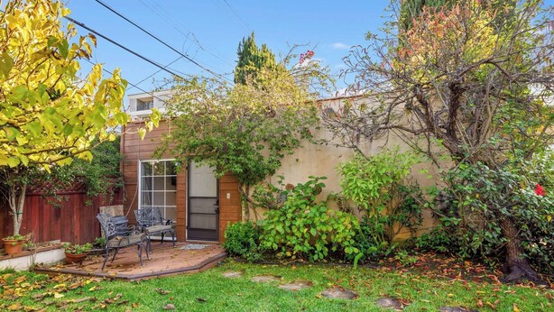 A backyard with a patio, a wooden fence, and a tree. - Beverly Hills Home Guest House & Hot Tub (Beverly Hills)