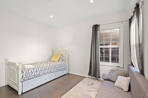 Un dormitorio con cama, sofá, ventana y vistas al exterior.