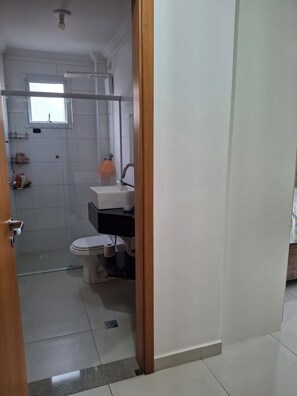 Un baño con inodoro, lavabo y zona de ducha.