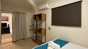 A hotel room with a bed, a wardrobe, a desk, and a large window. - CABO DOWNTOWN STUDIOS: 2BR Studio in heart of town walk anywhere #2 (Cabo San Lucas)