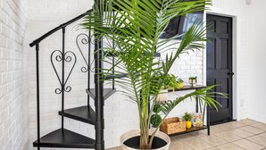 A staircase with a black metal railing, a potted plant, and a door in the background. - Pool Oasis -Near RJ Stadium, Hyde Park & Downtown (Tampa)