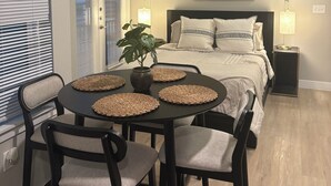A bedroom with a bed, bedside lamps, a ceiling fan, and a large abstract painting on the wall. - Enjoyable Studio apartment near downtown Fort Worth (Fort Worth)