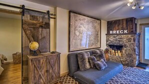 A cozy living room with a sofa, a globe, a map, and a fireplace labeled 'BRECK.' - BEST LOCATION! Cozy condo on Main Street. Walk to gondola. (Breckenridge)