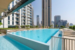 Ein Schwimmbad mit Stadtansicht im Hintergrund.