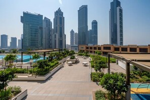 Eine Dachterrasse mit Pool, Sitzbereichen und Stadtansicht im Hintergrund.