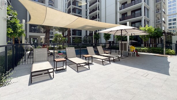 Eine Dachterrasse mit Sitzgelegenheiten im Freien und einem Pool.