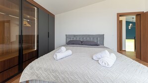 Une chambre avec un grand lit, une armoire et une vue sur l’extérieur.