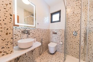 Ein Badezimmer mit Waschbecken, Toilette und Dusche.