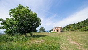 Une maison avec vue sur la mer, entourée de verdure.
