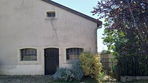 Un edificio con entrada empedrada, una ventana pequeña y una puerta.