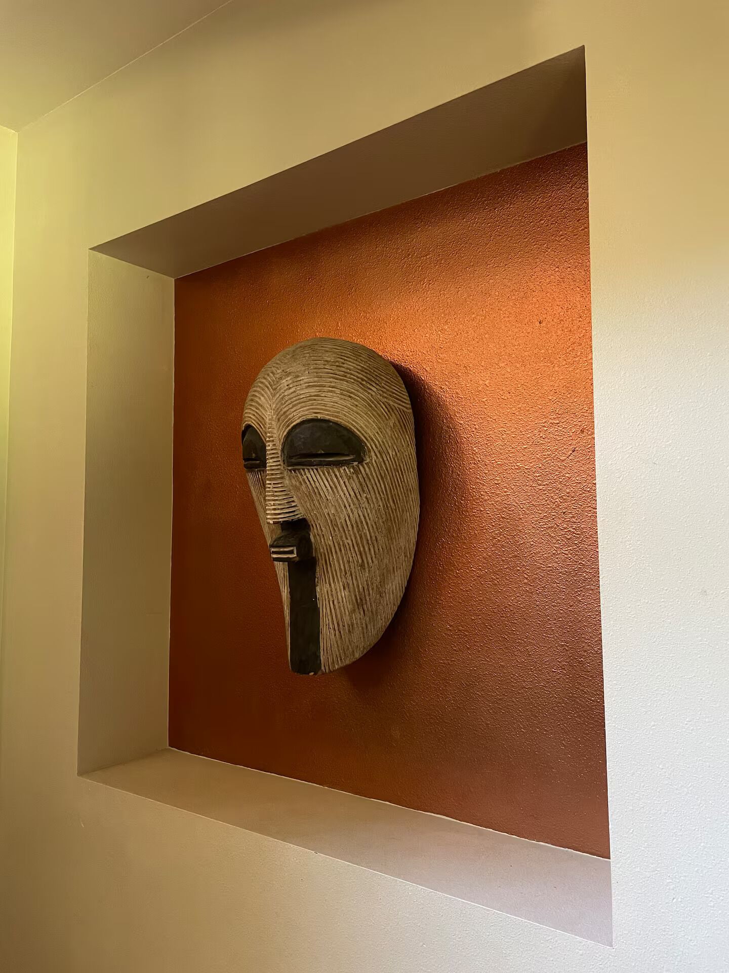 Una escultura fijada a la pared en un nicho empotrado.