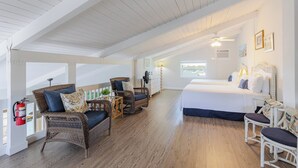 A spacious room with a large bed, wicker furniture, a ceiling fan, and a view of the sea. - Boot Key Harbor Oasis a 2-bedroom, 2-bath half duplex on Boot Key Harbor (Marathon)
