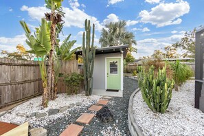 Un petit bâtiment d’un seul étage, doté d’une porte verte, entouré de cactus et de palmiers, et auquel mène un chemin de gravier.