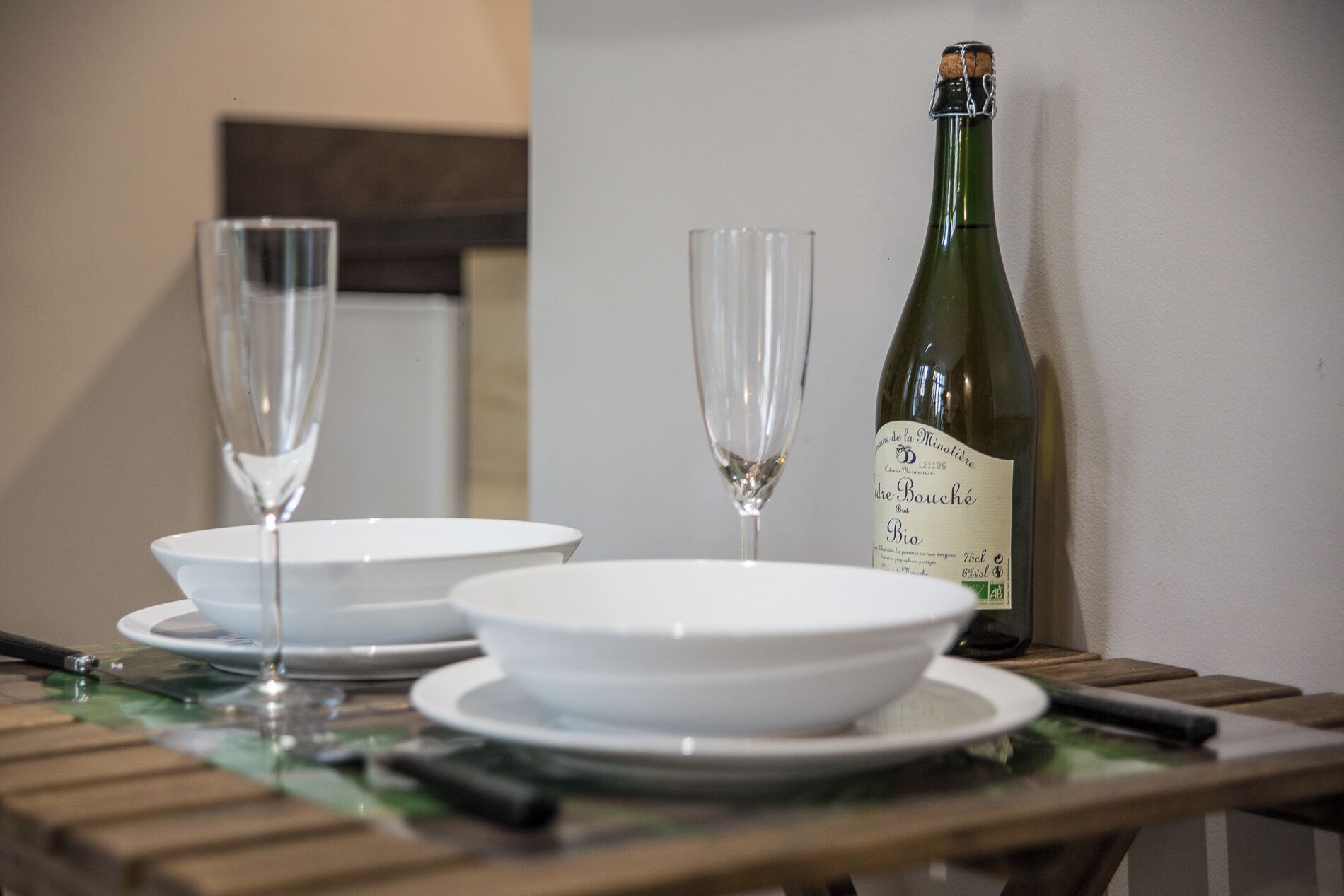 A table with two wine glasses and a bottle of wine.
