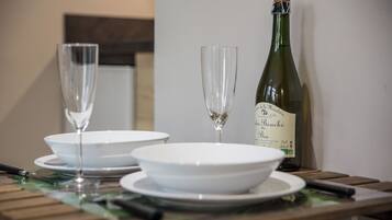 A table with two wine glasses and a bottle of wine.