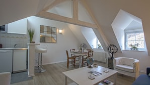Un appartement de style « loft » comprenant une cuisine, un coin repas et un espace de vie.