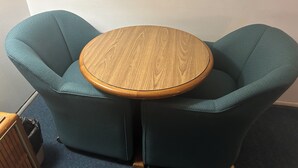 Une table ronde en bois, avec une chaise de chaque côté.