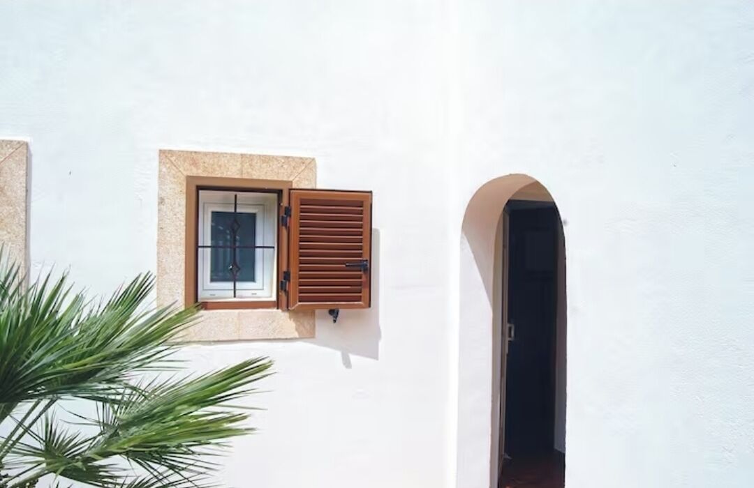 Un edificio blanco con una ventana y una puerta.