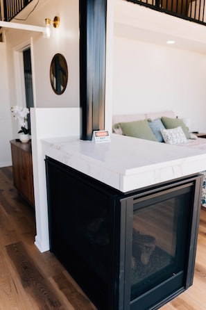 Una cucina moderna con un piano di lavoro in marmo, una cappa aspirante nera e un forno integrato.