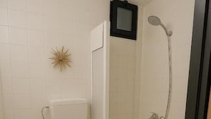 Un baño pequeño con inodoro, lavamanos y ducha.