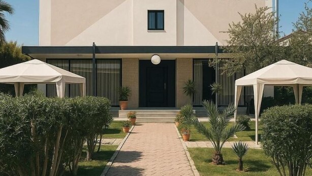 A modern hotel named 'HOTEL PANORAMA' with a central entrance, potted plants, and two white tents. - HOTEL PANORAMA ÖZDERE (Menderes)