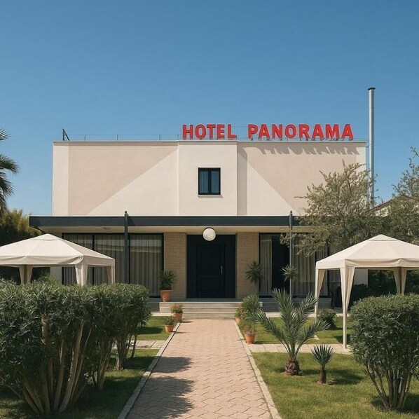 A modern hotel named 'HOTEL PANORAMA' with a central entrance, potted plants, and two white tents. - HOTEL PANORAMA ÖZDERE (Menderes)