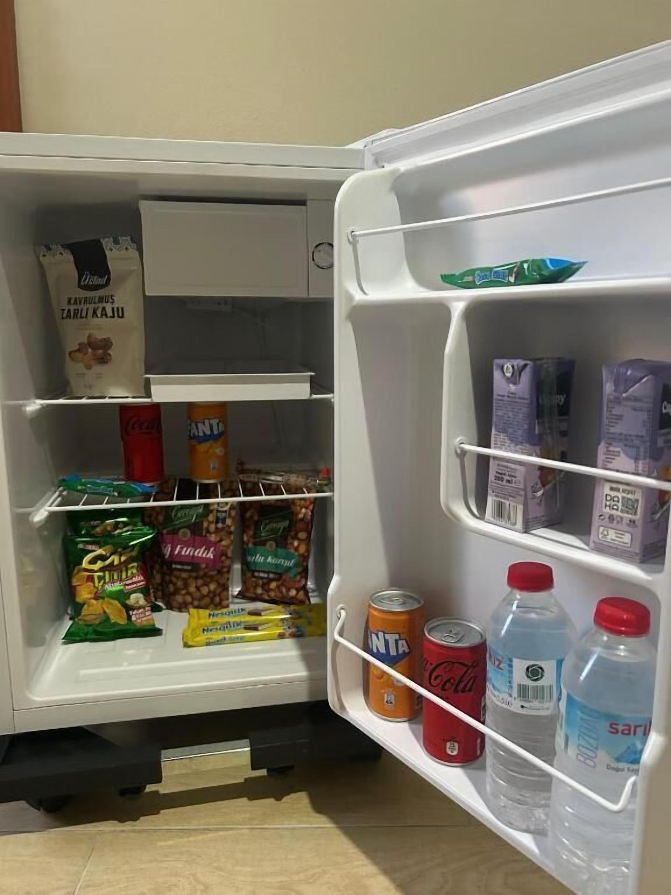 Un refrigerador lleno de aperitivos, bebidas y productos lácteos.