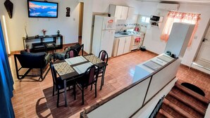 Un appartement moderne comprenant un coin repas, une cuisine et un escalier.