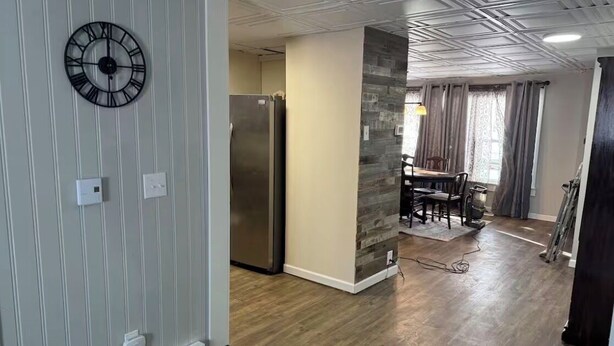 A modern kitchen with a built-in refrigerator, a dining area with a table and chairs, and a stone accent wall. - Quiet Place Close to Utica, Cooperstown, Thruway, and NYS Canal Trail (Mohawk)