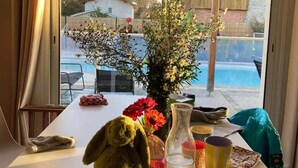 Una mesa con un peluche, un florero con flores y varias tazas.