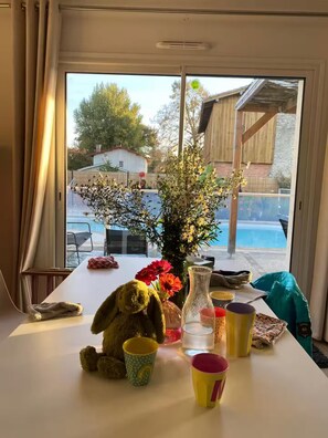 Ein Tisch mit einem Stofftier, einer Blumenvase und verschiedenen Tassen.