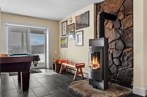 A room with a pool table, a fireplace, and framed artwork on the wall. - The Pond House: Cozy Home with a View, Swimming Pond, and Hot Tub, Pet-Friendly! (Margaretville)