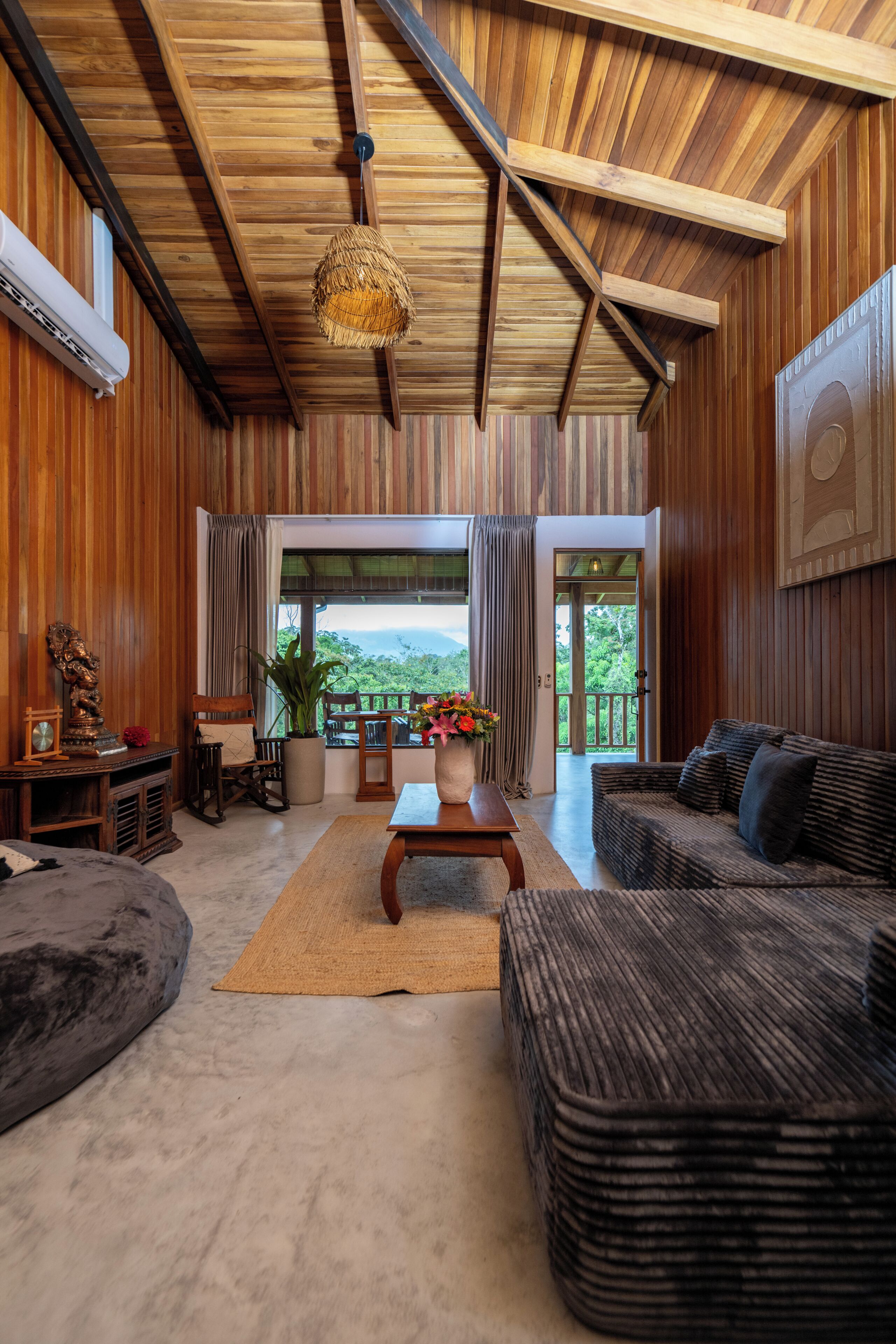 Un interior de madera con un sofá, una mesa, una silla y una planta en maceta.