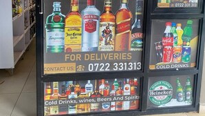 A liquor store with a sign advertising spirits, ciders, beers, wines, and champagne.